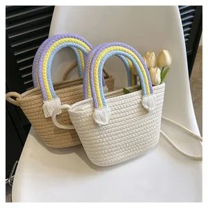 Detail der gewebten Baumwollseil-Handtasche mit Regenbogen-Griffen und weißen Quasten