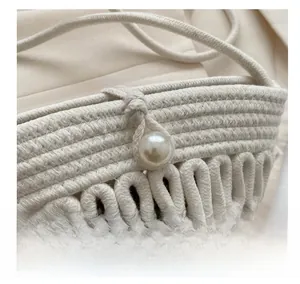 Close-up of dual-tone hand-woven texture with elegant faux pearl closure on summer bag