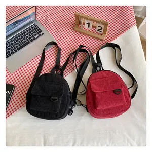Détail des mini sacs à dos en velours côtelé rouge et noir avec bretelles réglables