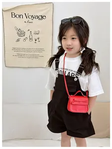 Detail of red girls mini crossbody bag with bow decoration and white stitching