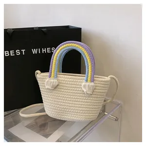 Detail der handgewebten Baumwollseiltasche mit bunten Regenbogen-Griffen und Fransen