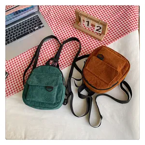 Détails de texture en velours côtelé sur mini sacs à dos vert vintage et marron caramel