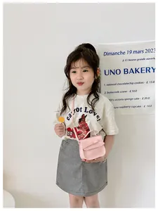 Pink girl's crossbody bag with bow detail shown on child model for size perspective