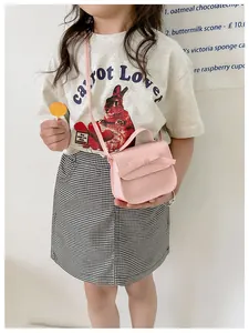 Close-up of pink girls' bow handbag with adjustable shoulder strap and top handle