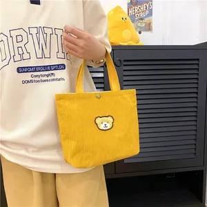 Leuke gele corduroy mini tote tas met geborduurde beer en een handige drukknoop