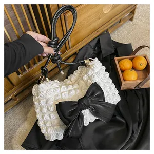 Detail der weißen Pufftextur mit großer schwarzer Schleife an einer modischen Tasche