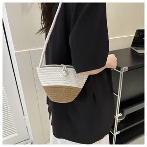 Close-up of hand-woven bucket bag with pearl buckle and contrast color weaving details