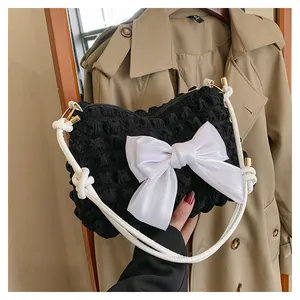 Detail der Puff-Struktur Tasche mit weißer Satinschleife und gewebtem Schultergurt