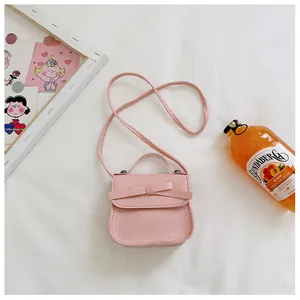 Detail showing pink girls crossbody bag with bow decoration and white stitching