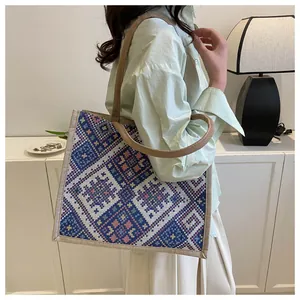 Detailed macro view of ethnic geometric pattern fabric and woven linen handle of tote bag