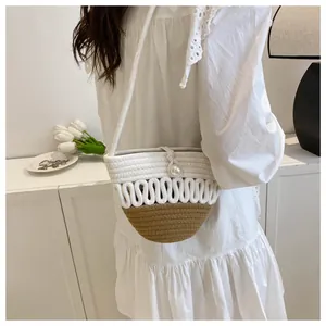 Detail of woven straw bag showing two-tone texture and large pearl buckle closure