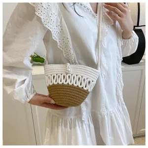 Detail of hand-woven straw bucket bag featuring a pearl button and cotton rope strap