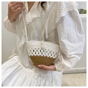 Detail of woven bucket bag with beige textures, khaki base and pearl button on model