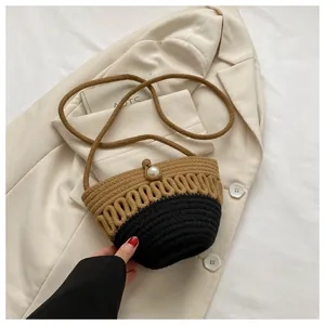 Detail of handwoven bucket bag featuring a pearl clasp and contrast weave design