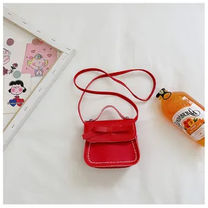 Red mini crossbody bag for girls featuring a decorative bow and white contrast stitching