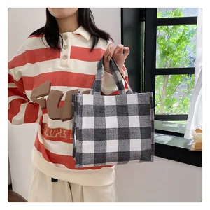 Détail du sac cabas en toile à carreaux montrant la texture tissée noire et blanche