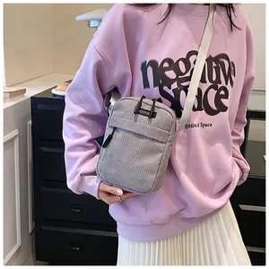 Detail of light purple corduroy crossbody bag with vertical texture and zip pocket