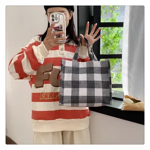 Détail du sac cabas en toile à damier noir et blanc avec texture tissée et poignée