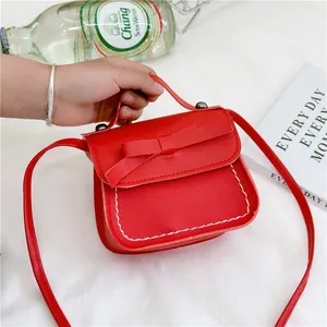 Red mini crossbody bag for girls with bow decoration and white contrast stitching detail