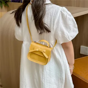 Cute yellow mini crossbody bag for girls with bow decoration and white stitching details