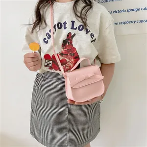 Pink bow mini crossbody bag for girls made of PU leather shown on child model