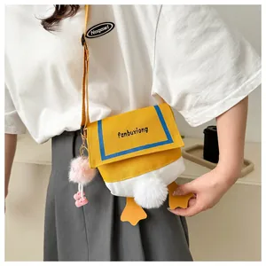 Detail of cute yellow cartoon duck canvas crossbody bag with fluffy tail and charm