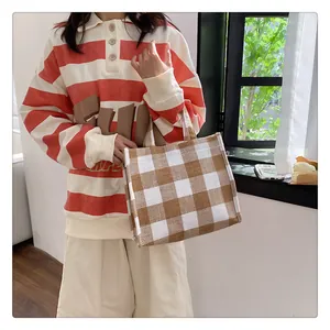 Détail d'un sac cabas en toile à carreaux marron et blanc avec texture en lin naturel