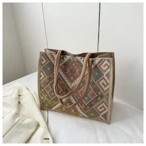 Detailed close-up of woven tote bag with colorful ethnic geometric diamond texture