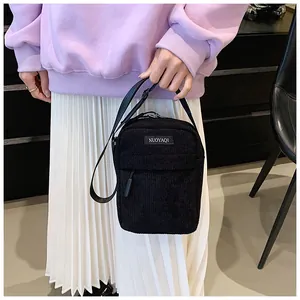 Detailed view of black corduroy crossbody bag texture and NUOYAQI woven brand label