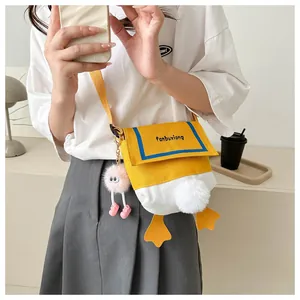 Detail of cute cartoon duck canvas crossbody bag featuring plush charms and tail