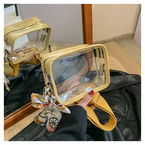 Close-up of clear PVC crossbody bag with yellow leather trim and a patterned scarf detail