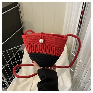 Detail of red and black woven mini shoulder bag with large pearl and wave texture