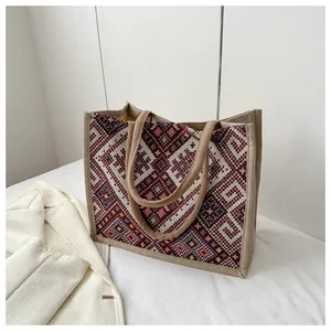 Macro detail of red geometric jacquard embroidery on large canvas ethnic tote bag