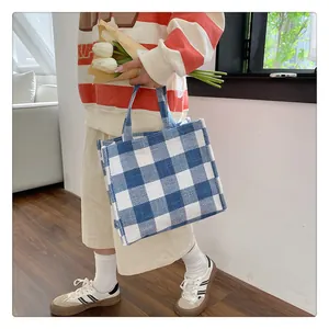 Vue détaillée du sac cabas à carreaux bleu et blanc montrant la texture du tissu tissé