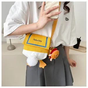 Detail of cute duck-shaped canvas crossbody bag with fluffy tail and burger charm