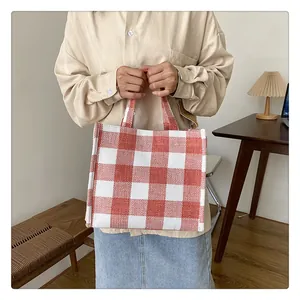 Détail du sac cabas en toile à carreaux vichy rouge et blanc montrant la texture du tissu