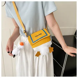 Cute cartoon duck canvas crossbody bag with plush charm and 3D feet shown on model