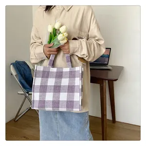 Gros plan d'un sac cabas à carreaux violets et blancs en toile tissée texturée
