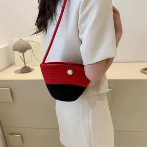 Minimalist woven bucket bag with red and black color-blocking and white pearl closure
