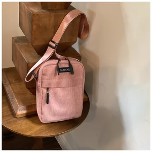 Close-up of pink corduroy crossbody bag showing vertical texture and NUOYAQ brand logo