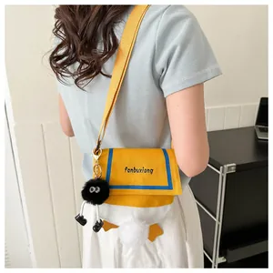 Detail of cute duck-themed canvas crossbody bag featuring fluffy tail and plush charm