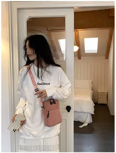 Pink corduroy crossbody bag shown with a white SoulSense sweatshirt on a model