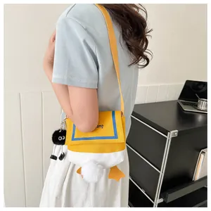 Side view of a cute cartoon duck canvas crossbody bag with plush tail and black doll charm