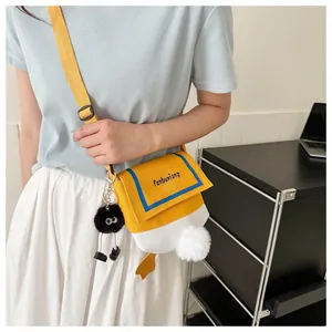 Detail of cute duck-shaped canvas crossbody bag with plush feet and adjustable strap