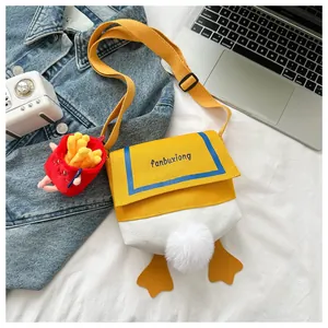 Detail of cartoon duck canvas crossbody bag with fluffy tail and fries plush pendant
