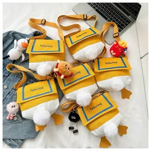 Detail of cute duck-themed canvas crossbody bags with plush charms and adjustable straps