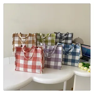 Détails de six sacs cabas en toile à carreaux vichy colorés sur un bureau élégant
