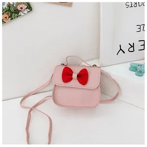 Detail einer rosa Kinderhandtasche mit roter Schleife und weißen Kontrastnähten aus PU
