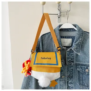 Detail view of the yellow canvas duck bag with embroidery and plush fries keychain charm