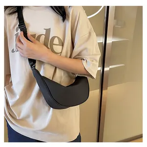 Primo piano della borsa a mezzaluna nera indossata dal modello con tracolla regolabile